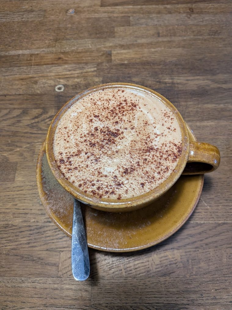 Cappuccino dusted with chocolate in a mustard-yellow cup