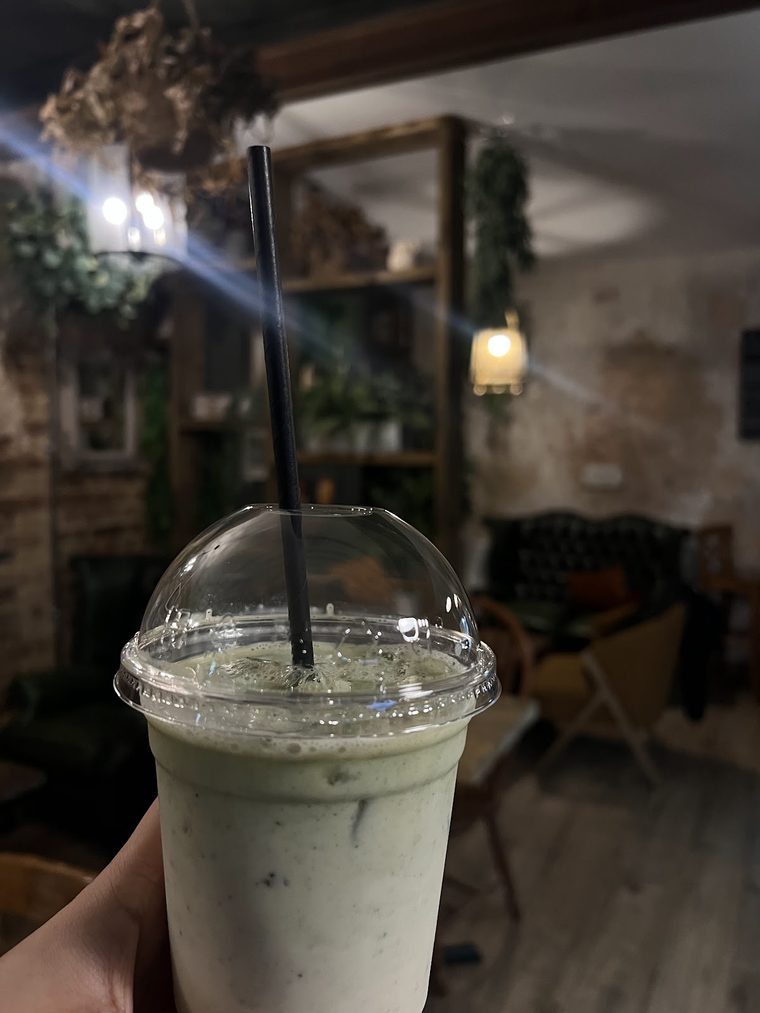 Iced matcha latte in a tall domed cup